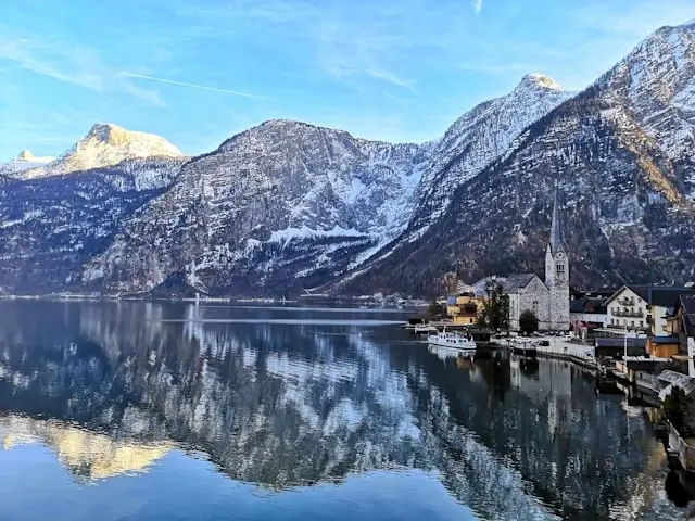 Hallstatt Austria lakeside village with alpine mountains reflected in calm water - picturesque European destination