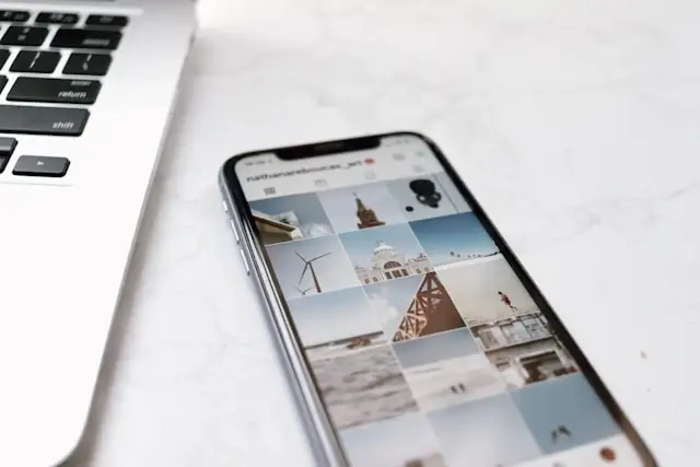 Instagram feed displaying travel photos on smartphone next to laptop - social media content creation for travelers