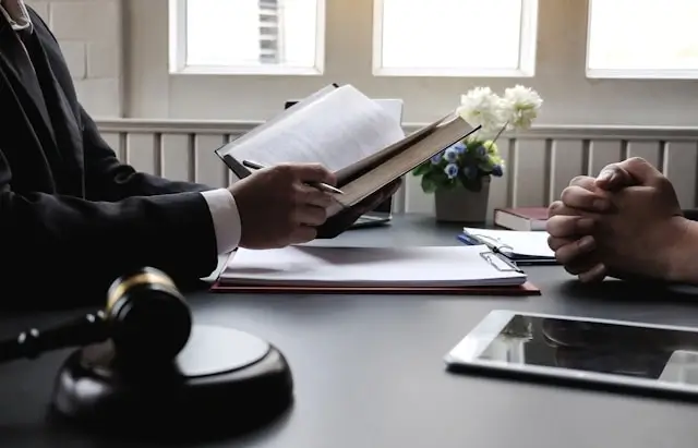 Lawyer studying legal documents with gavel and digital tablet, showcasing professional development through remote legal learning