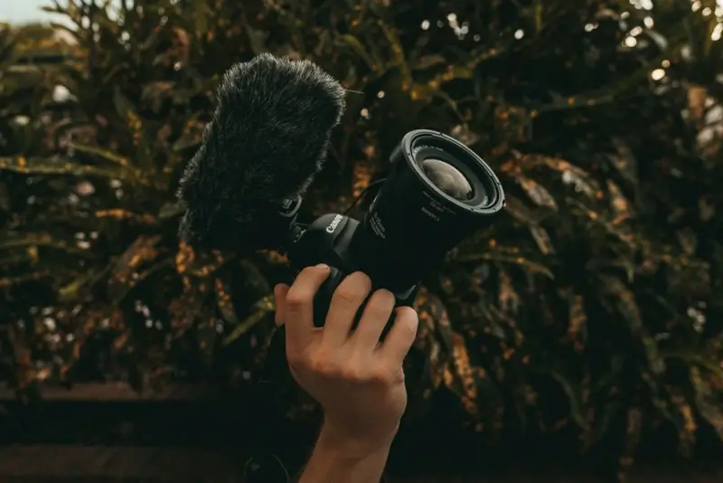 DSLR camera with shotgun microphone and windscreen for outdoor vlogging - directional mic setup for travel content