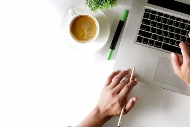 Student studying law online from home with laptop and coffee, illustrating the comfort and flexibility of remote legal education and work-life balance