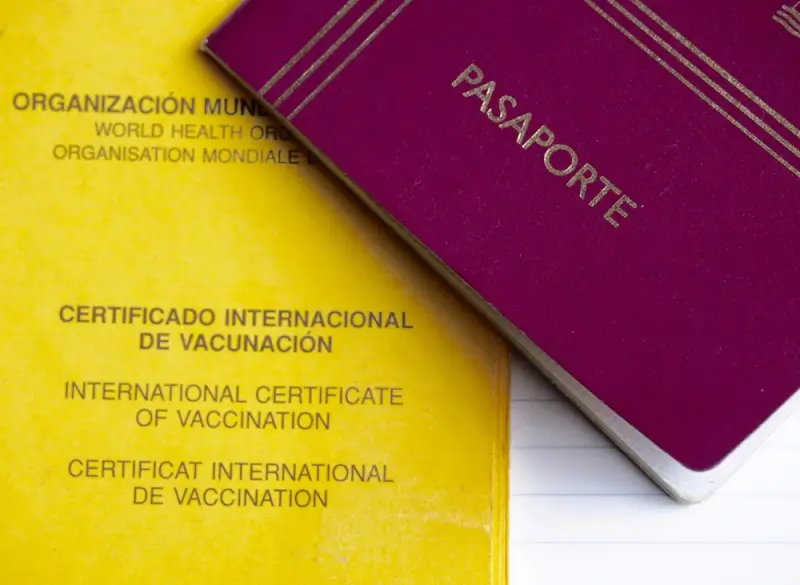 Passport and WHO international vaccination certificate documents for travel health requirements and border crossing