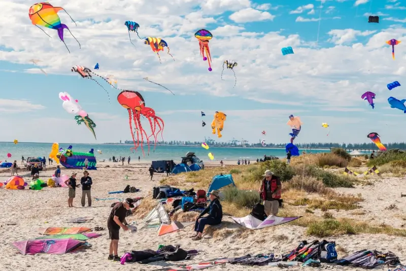 Colorful kites flying at Adelaide International Kite Festival on Semaphore Beach, South Australia with crowds enjoying the outdoor event