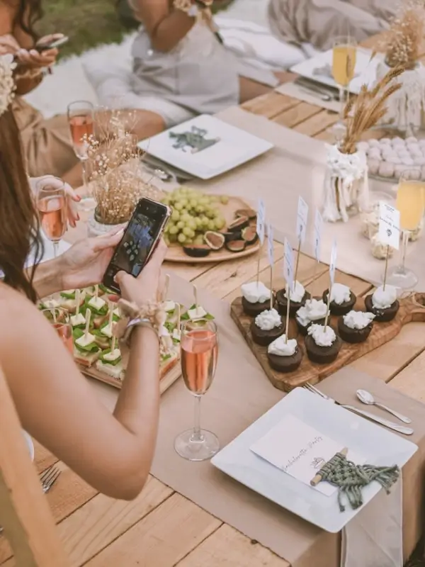 Women enjoying wine and gourmet food at outdoor culinary bachelorette party celebration