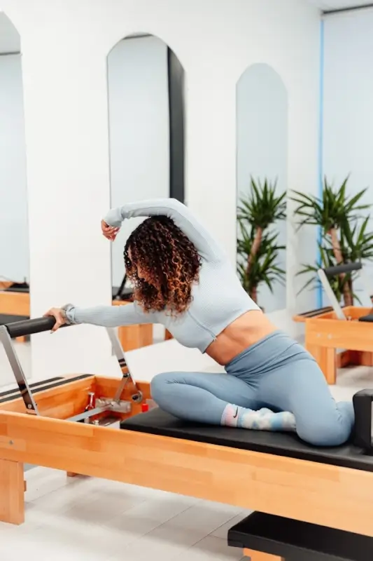 Woman doing pilates reformer exercise for flexibility and strength training