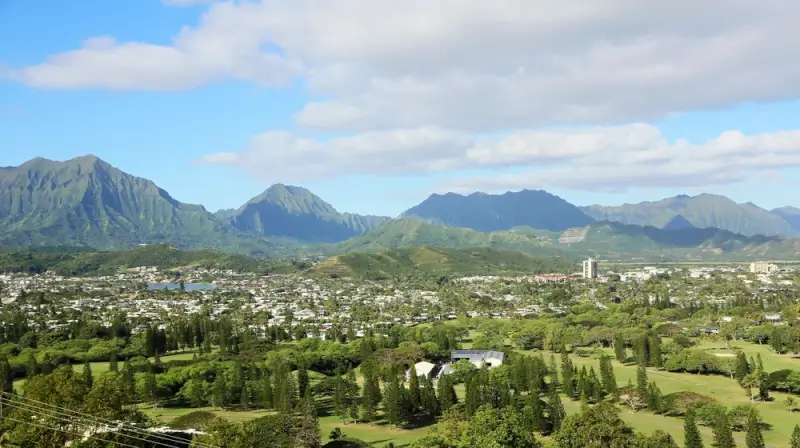 Panoramic view of Kailua Town with lush green landscape, residential areas, and dramatic mountain ranges in the background on Oahu, Hawaii