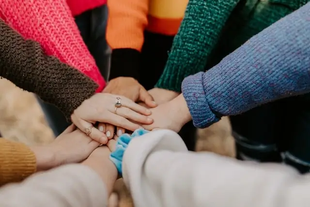 Group of people joining hands together showing social connection and support