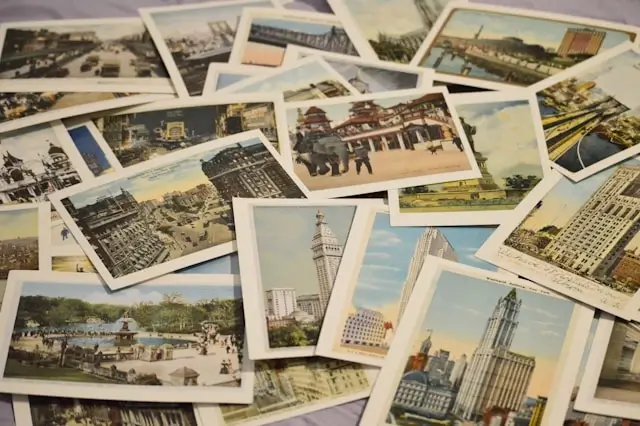 Collection of vintage travel postcards scattered on a surface, featuring various landmarks, cityscapes, and architectural scenes from different destinations