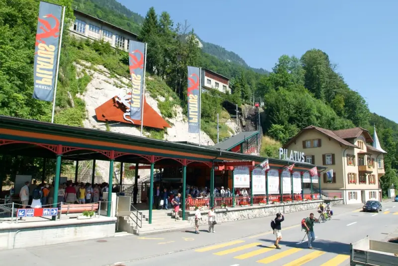 Pilatusbahn valley station with visitors and mountain backdrop in summer, Central Switzerland