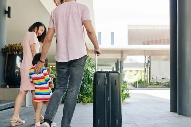 Family with luggage arriving at a small hotel for a weekend getaway stay