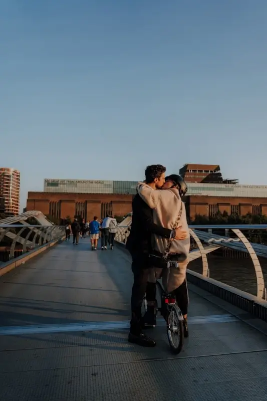 Couple kissing on Millennium Bridge in London during one of the best romantic UK breaks