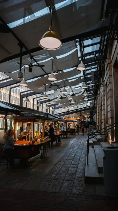 Interior of Boston Public Market with local vendor stalls, hanging pendant lights, and decorative fabric ceiling