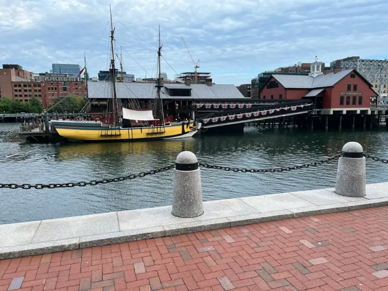 Historic replica ship docked at Boston Tea Party Ships & Museum on the waterfront with brick walkway