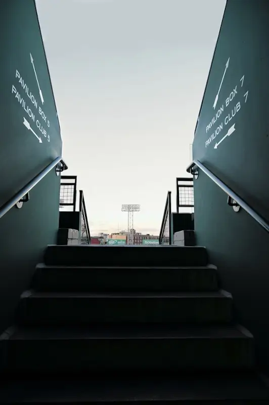 View from beneath Fenway Park bleachers looking up toward the baseball field and stadium lights