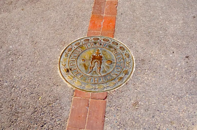 Freedom Trail medallion embedded in red brick path, one of the most popular things to do in Boston