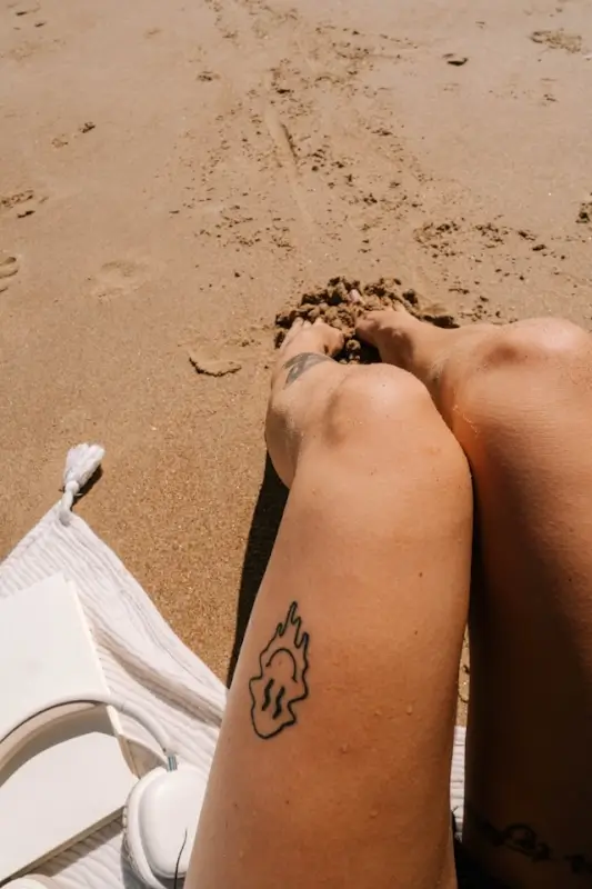 Traveler relaxing on beach contemplating homesickness during extended trip abroad