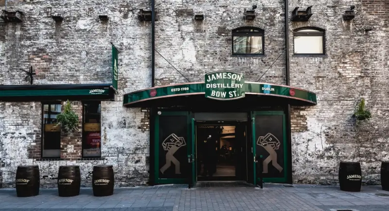 Jameson Distillery entrance on Bow Street in Dublin with weathered brick facade and iconic green signage, established 1780