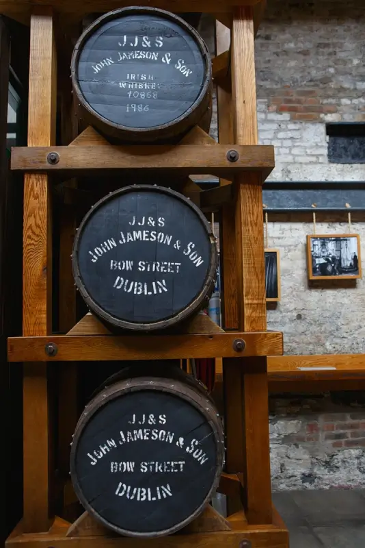 Vintage wooden whiskey barrels stacked on display at Jameson Distillery in Dublin, showing traditional Irish distilling craftsmanship