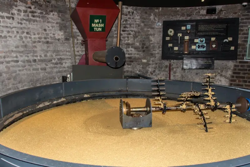 Traditional mash tun filled with grains at a Dublin distillery, demonstrating the whiskey-making process during an educational tour