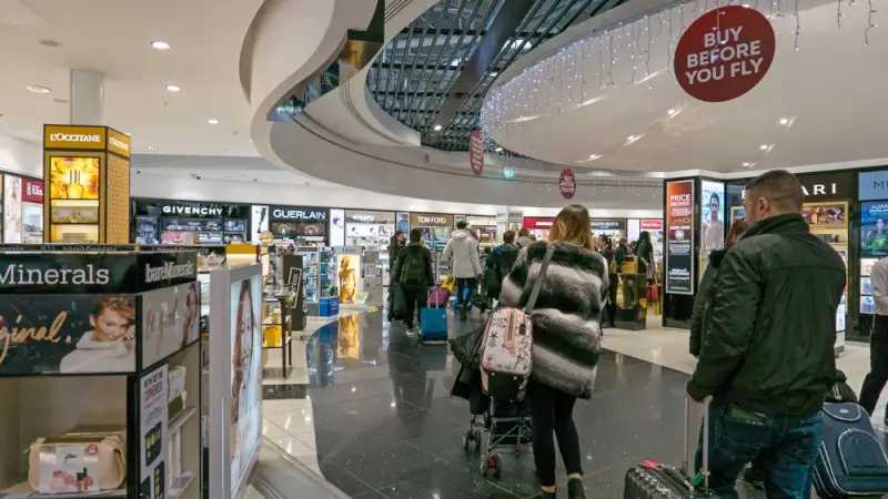World Duty Free shopping area at STN with luxury brands and travelers in departure terminal
