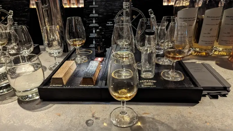 Professional whiskey tasting setup with multiple glasses and sample bottles arranged on tasting trays at an Irish distillery