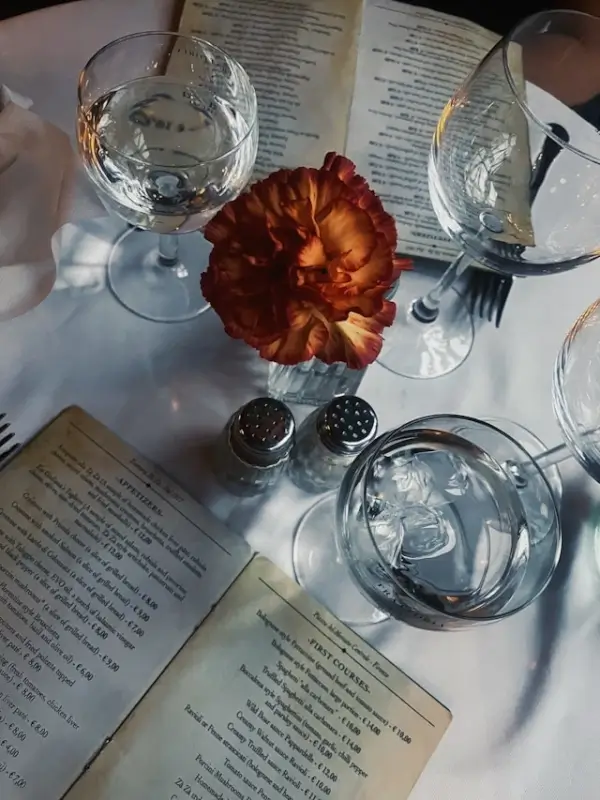 Elegant table setting with wine glasses and flower at Italian corporate dining event