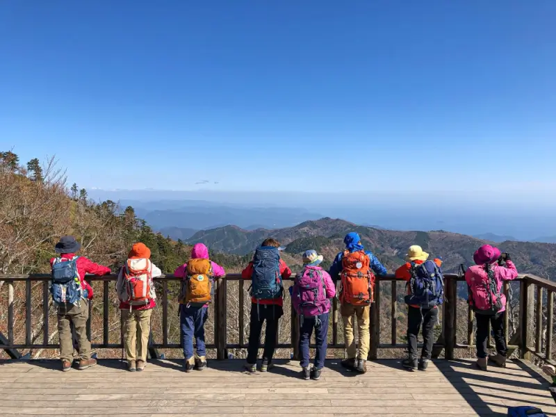 Group of hikers with backpacks enjoying mountain view on budget-friendly outdoor adventure